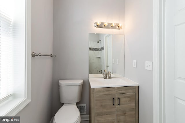 bathroom with vanity, a healthy amount of sunlight, and toilet