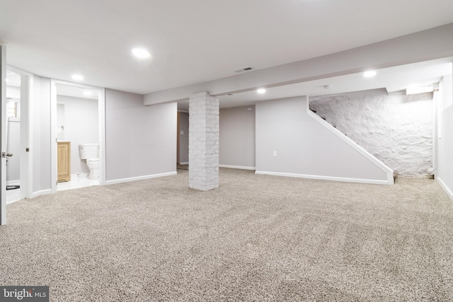 basement featuring carpet flooring and brick wall