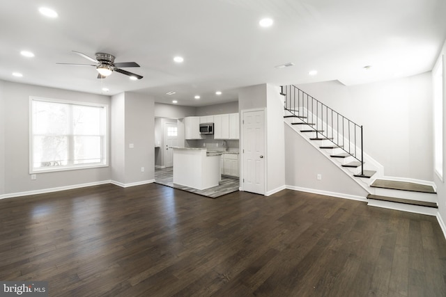 unfurnished living room with ceiling fan, sink, and dark hardwood / wood-style floors