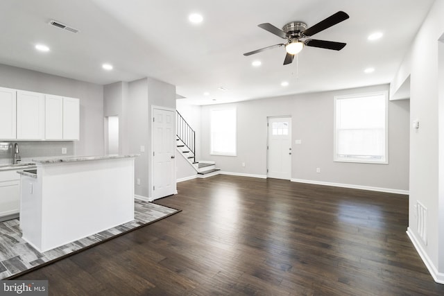 kitchen with ceiling fan, white cabinetry, and hardwood / wood-style floors