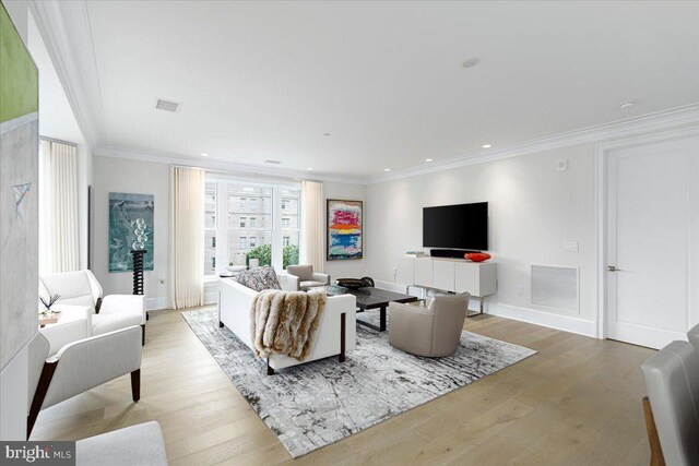 living room featuring light hardwood / wood-style floors and crown molding