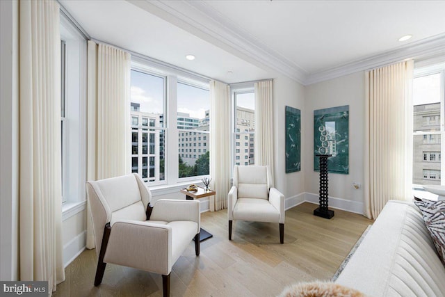 sitting room with plenty of natural light, light hardwood / wood-style floors, and ornamental molding