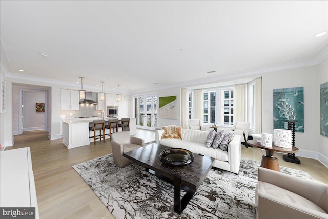 living room with light hardwood / wood-style floors, ornamental molding, and french doors