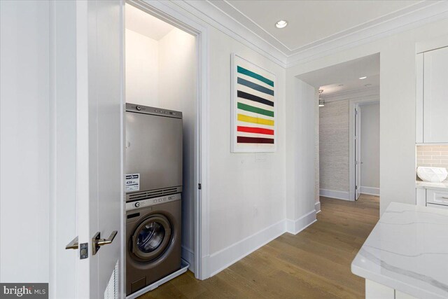 interior space featuring hardwood / wood-style flooring, crown molding, and stacked washer and dryer