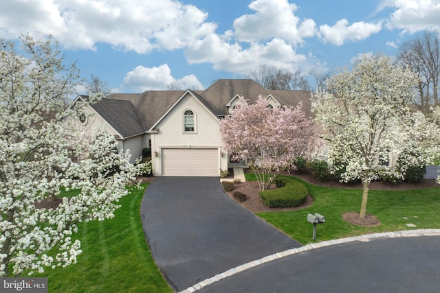 view of front of home with a front yard and a garage