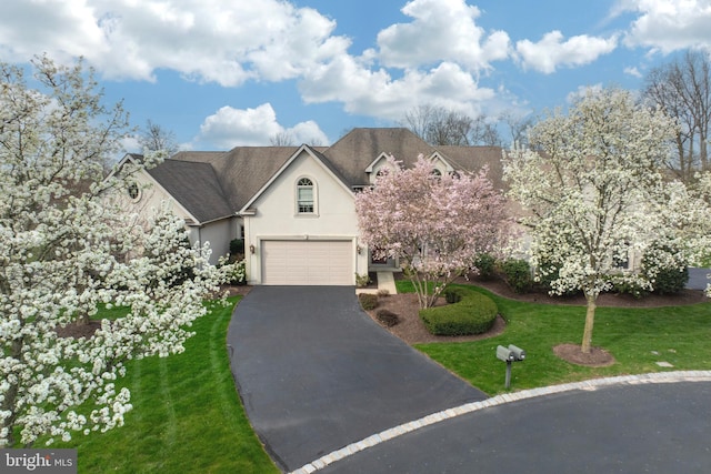 view of front of property featuring a garage and a front lawn