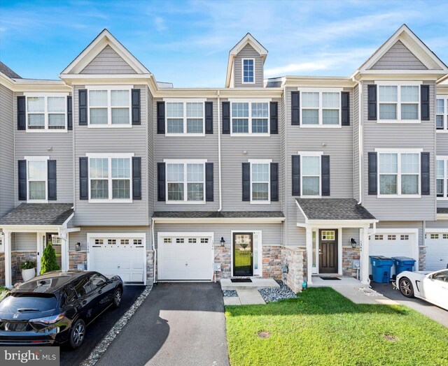 townhome / multi-family property featuring a garage and a front lawn