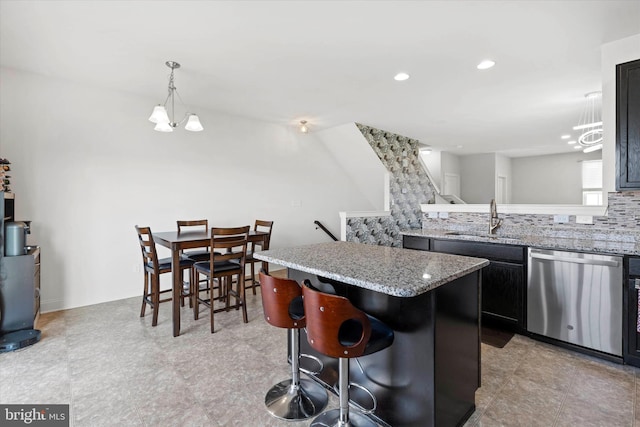 kitchen with stainless steel dishwasher, tasteful backsplash, sink, light stone countertops, and light tile patterned floors