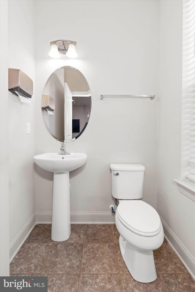 bathroom with toilet and tile patterned flooring