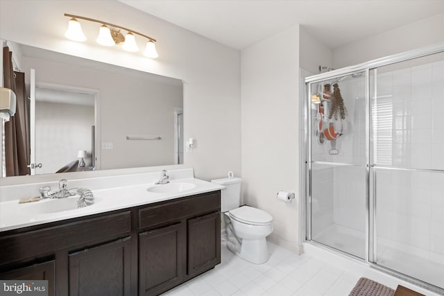 bathroom featuring dual vanity, toilet, tile patterned floors, and a shower with shower door