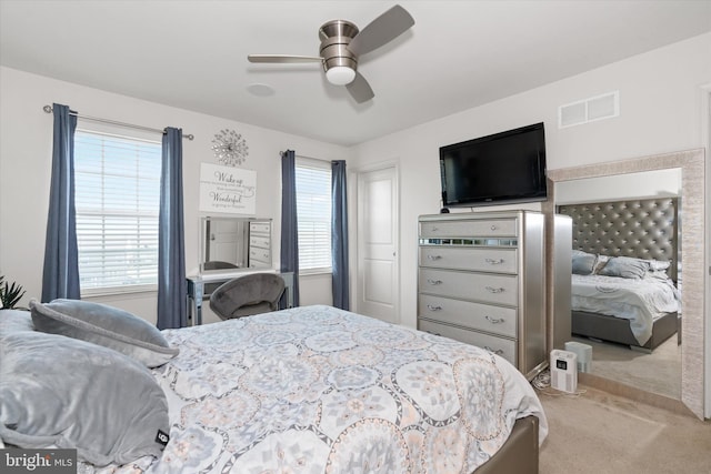 carpeted bedroom with ceiling fan and multiple windows