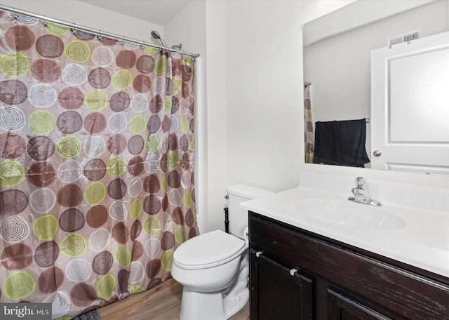 bathroom with toilet, hardwood / wood-style flooring, and vanity