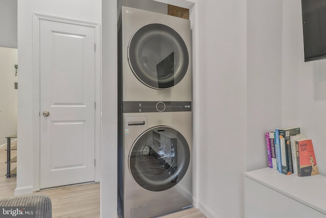 laundry area featuring light wood-type flooring and stacked washer and dryer