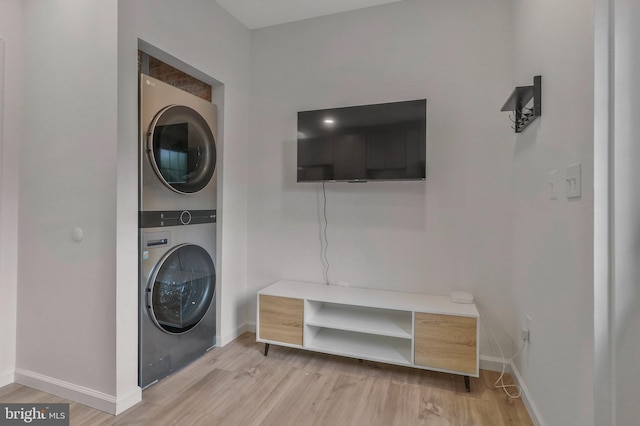 laundry area with light wood-type flooring and stacked washer / dryer