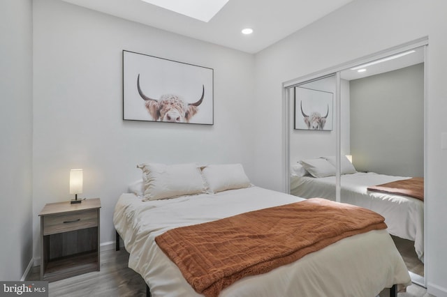 bedroom with dark hardwood / wood-style flooring and a closet