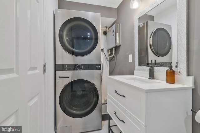 washroom featuring stacked washing maching and dryer and sink