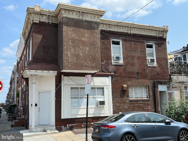 view of front of home featuring brick siding and cooling unit