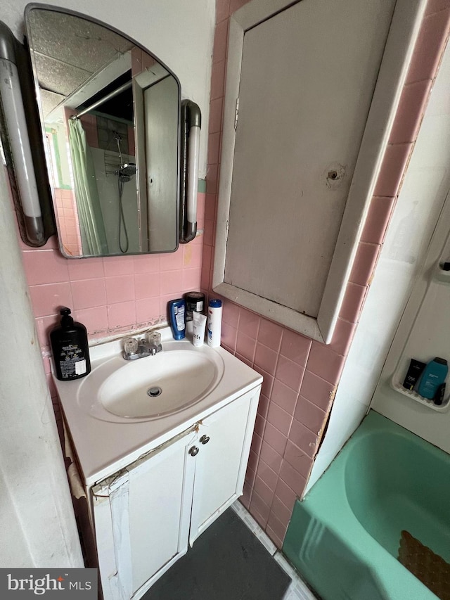 bathroom featuring decorative backsplash, tile walls,  shower combination, and vanity