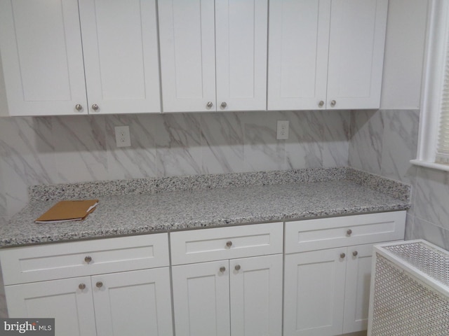 kitchen featuring white cabinets and backsplash