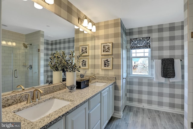 bathroom featuring walk in shower, vanity, and wood-type flooring