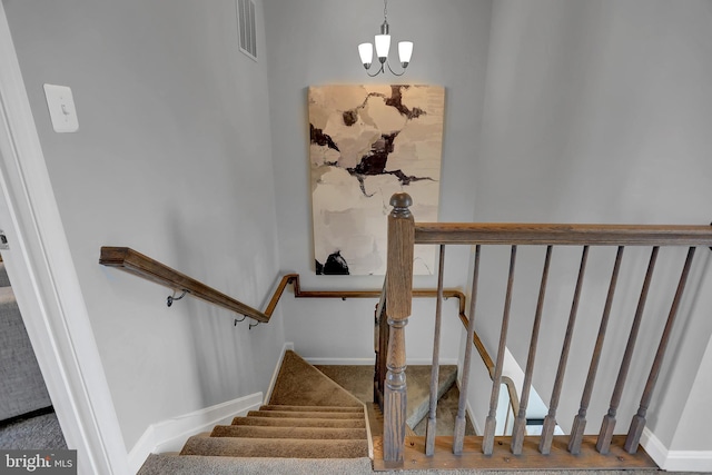 staircase with an inviting chandelier