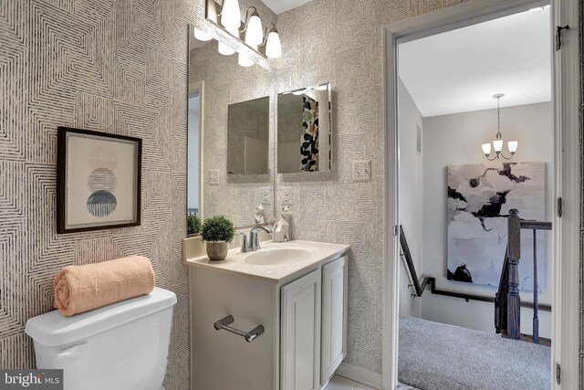 bathroom with vanity, a chandelier, and toilet