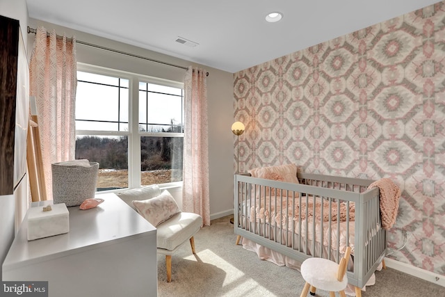 carpeted bedroom with a nursery area