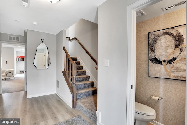 stairs featuring hardwood / wood-style floors