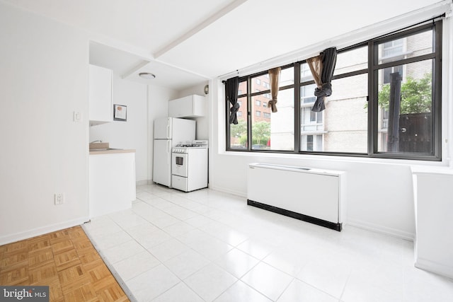 kitchen with light parquet floors, radiator heating unit, fridge, white cabinets, and white gas range