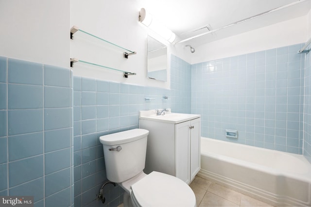 full bathroom featuring tile walls, tiled shower / bath combo, vanity, tile patterned floors, and toilet