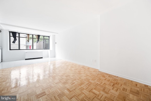 unfurnished living room featuring radiator heating unit and light parquet floors