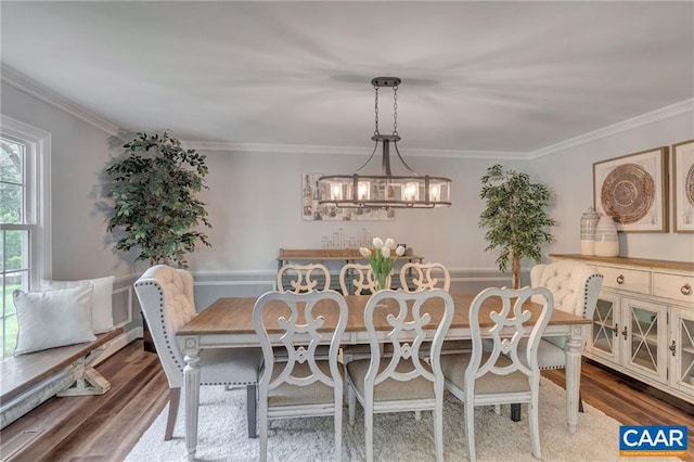 dining area featuring hardwood / wood-style floors, a chandelier, and crown molding