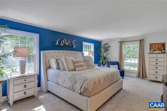 bedroom featuring light colored carpet and multiple windows