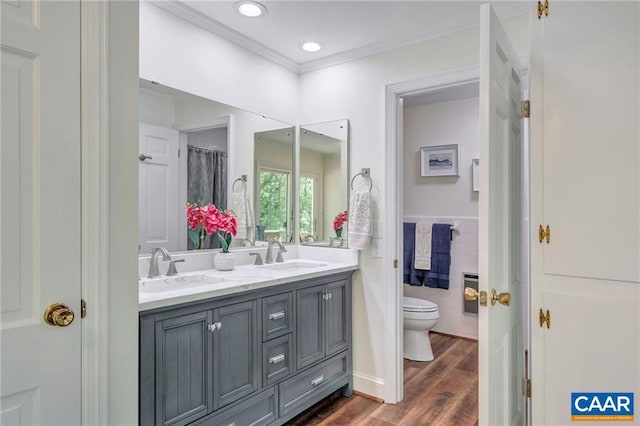 bathroom featuring crown molding, toilet, wood-type flooring, and double sink vanity