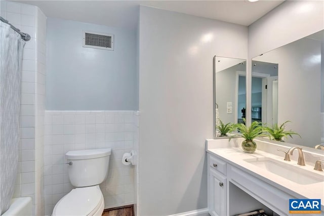 full bathroom featuring vanity, toilet, shower / tub combo with curtain, and tile walls