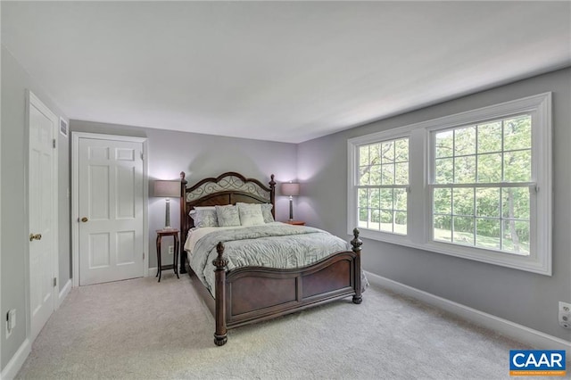 carpeted bedroom featuring multiple windows