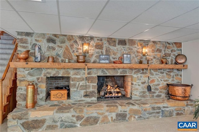 interior details with a paneled ceiling and a stone fireplace