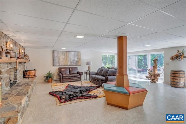 living room featuring a paneled ceiling and a stone fireplace