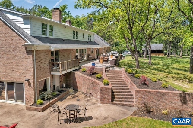 back of property with a yard and a patio