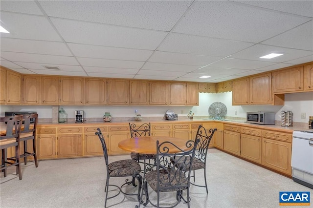 kitchen featuring light colored carpet, white electric range, and a drop ceiling