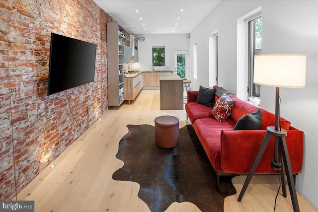 living room featuring light hardwood / wood-style flooring and brick wall