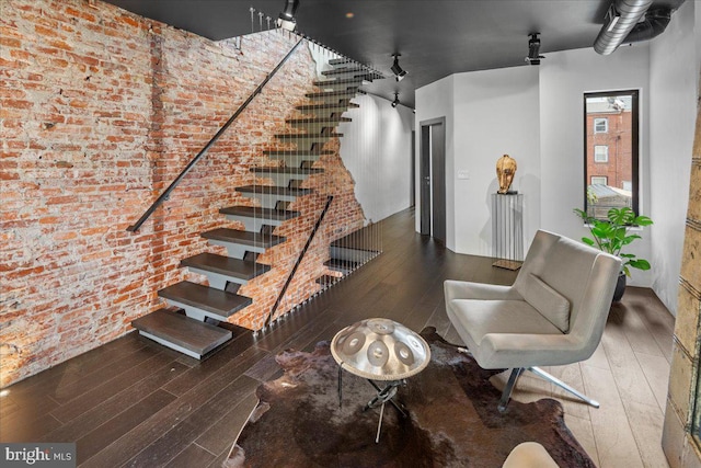 interior space featuring brick wall and wood-type flooring