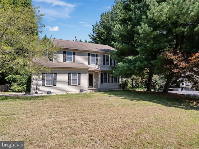 colonial home featuring a front lawn