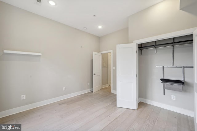 unfurnished bedroom featuring a closet and light hardwood / wood-style flooring