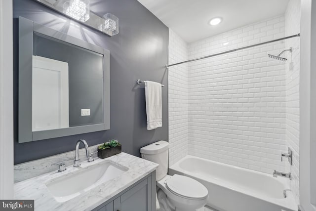 full bathroom with vanity, tiled shower / bath combo, and toilet