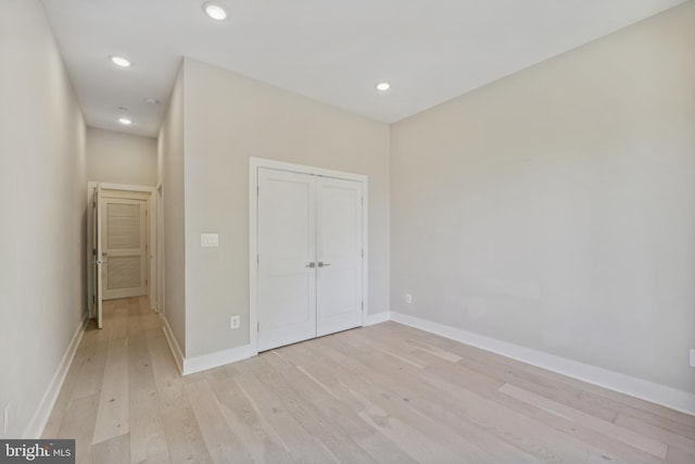 unfurnished bedroom featuring light hardwood / wood-style floors and a closet