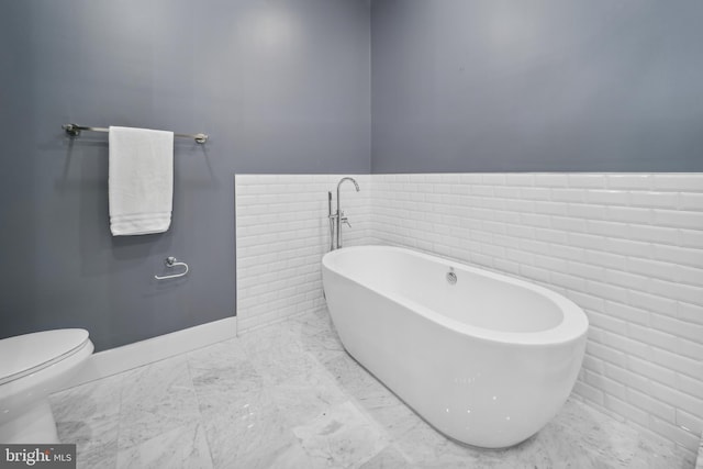 bathroom featuring a tub and toilet