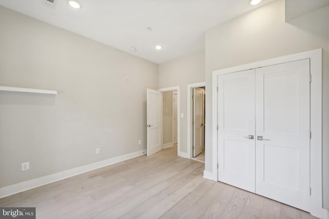 unfurnished bedroom with light hardwood / wood-style floors and a closet