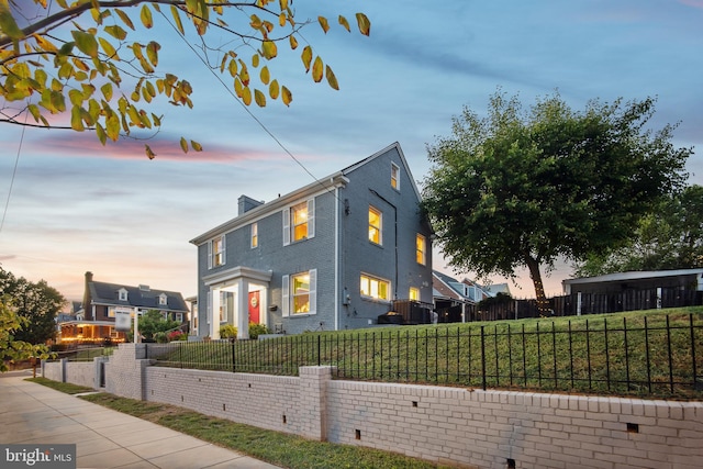 property exterior at dusk featuring a lawn