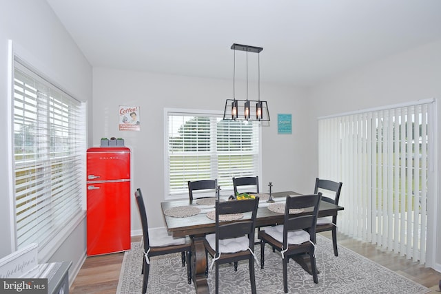 dining space featuring hardwood / wood-style flooring and a chandelier